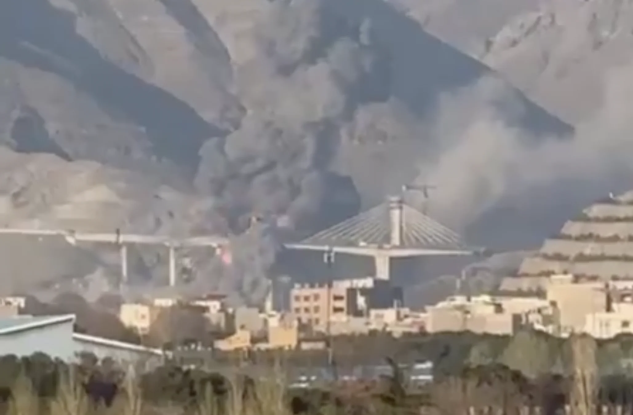B1 bridge aerial view — Iran's tallest bridge, inaugurated months earlier, collapsed in double JDAM strike; Iran condemns it as 'war crime' at UN Security Council