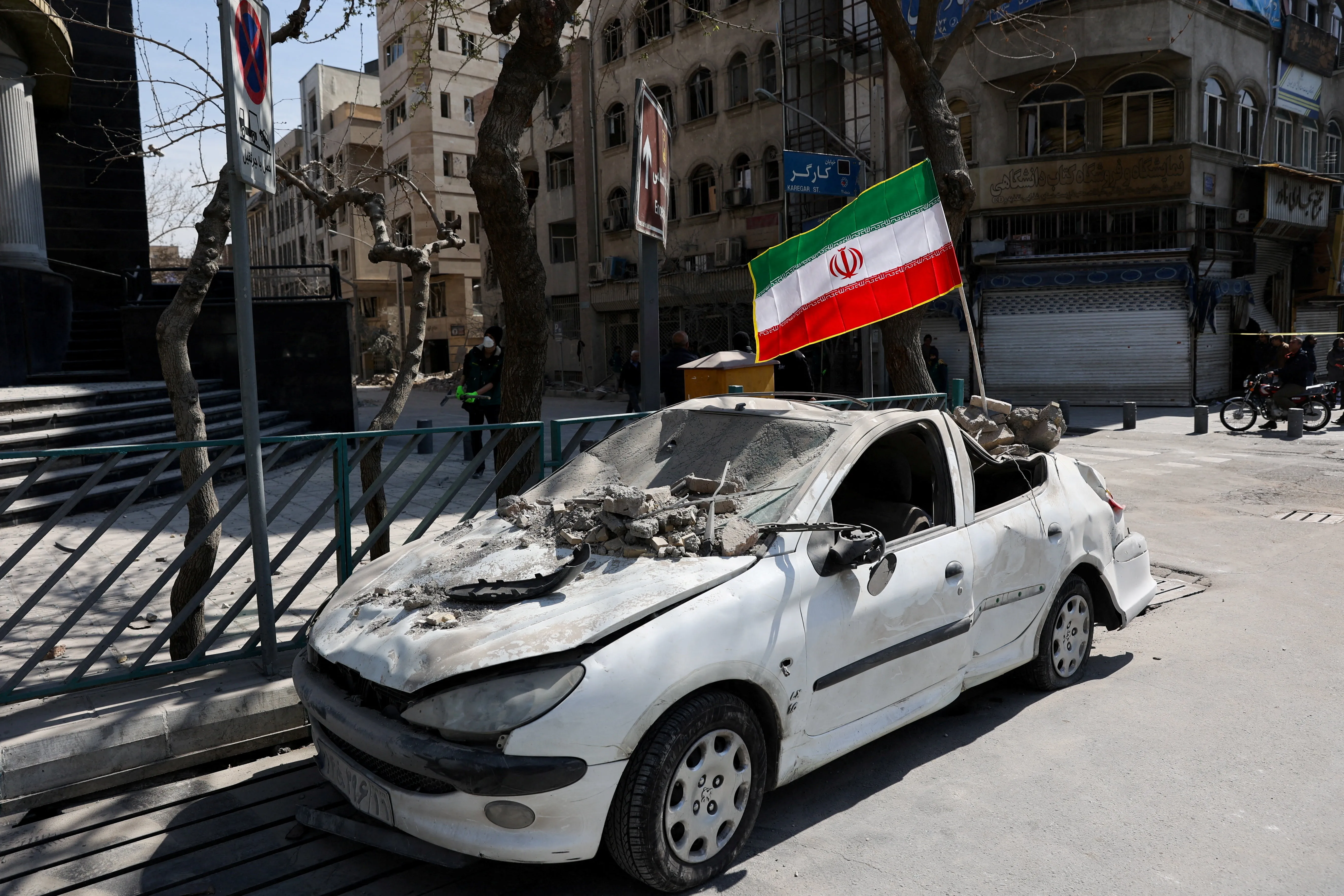 Tehran streets — Day 5 aftermath; abandoned vehicles and damaged infrastructure near government quarter strikes